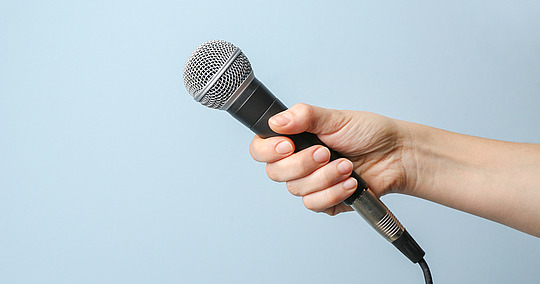 Hand hält Mikrofon