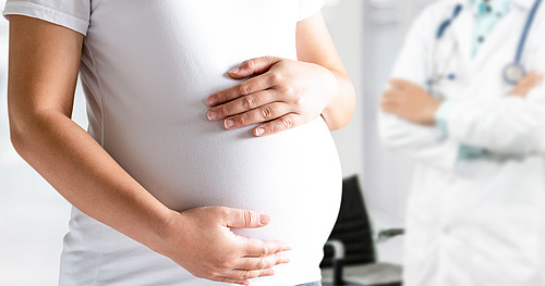 Schwangere umfasst ihren Bauch